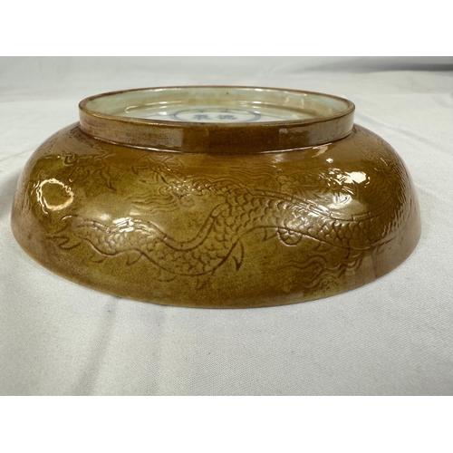 459 - A Chinese yellow shallow dish with incised dragon decoration to centre and outside rim, four charact... 