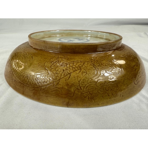 459 - A Chinese yellow shallow dish with incised dragon decoration to centre and outside rim, four charact... 