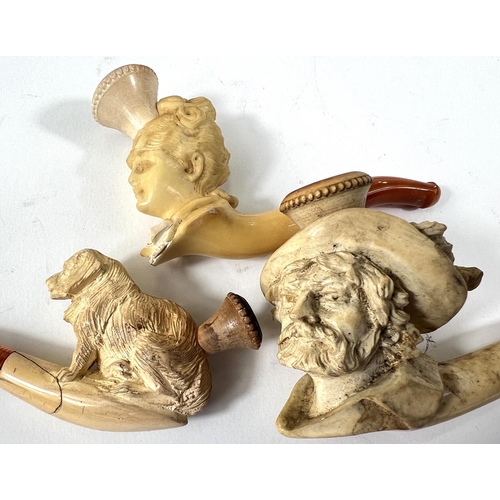 46 - 3 cased amber and Meerschaum pipes depicting seated dog (small crack); a woman's head;  a caval... 