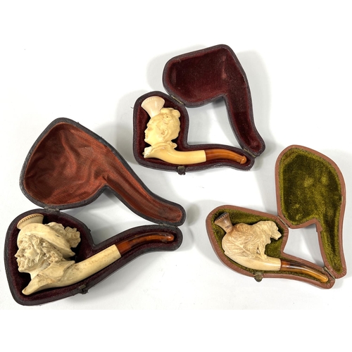 46 - 3 cased amber and Meerschaum pipes depicting seated dog (small crack); a woman's head;  a caval... 