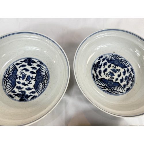 460 - A pair of Chinese blue and white lidded bowls with birds in clouds, six character mark to base and l... 