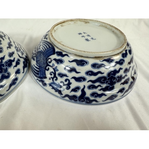 460 - A pair of Chinese blue and white lidded bowls with birds in clouds, six character mark to base and l... 