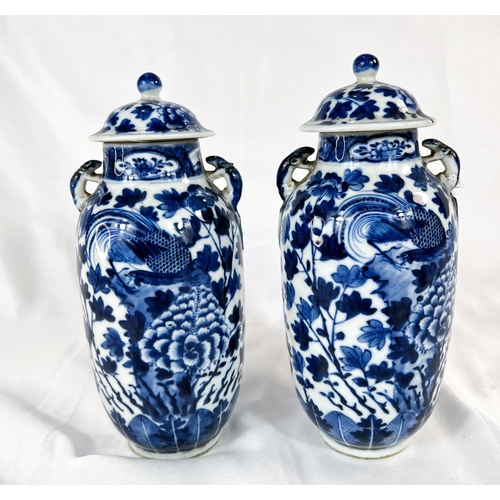 463 - A pair of Chinese 18th/19th Century lidded vases with marks for Kangxi period, blue and white with b... 