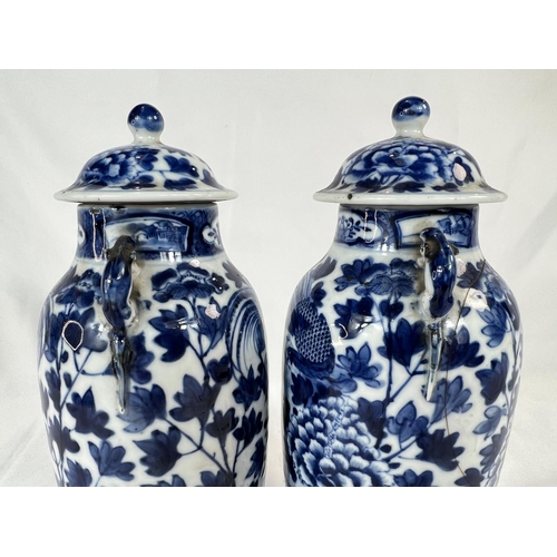 463 - A pair of Chinese 18th/19th Century lidded vases with marks for Kangxi period, blue and white with b... 