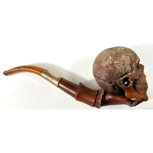 49 - A cased amber and Meerschaum pipe in the form of a skull with chased silver mounts, length 20cm.