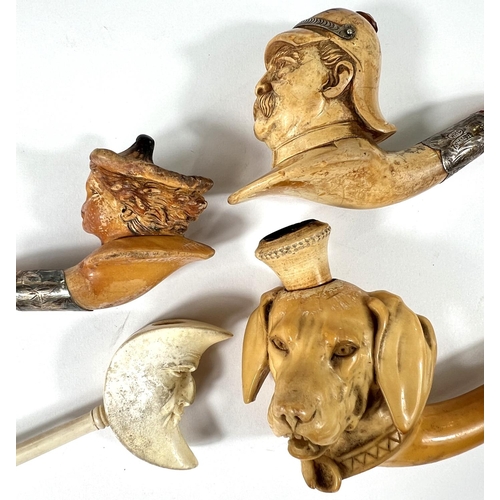 52 - 4 cased amber and Meerschaum pipes depicting Prussian officer's head,  man in the moon, woman's head... 