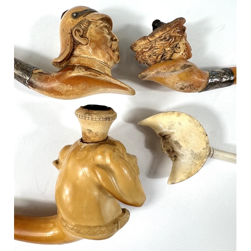 52 - 4 cased amber and Meerschaum pipes depicting Prussian officer's head,  man in the moon, woman's head... 