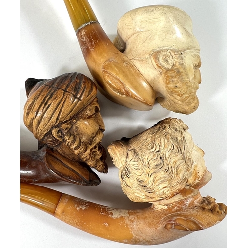 54 - 3 amber and Meerschaum pipes, 2 cased, depicting:- Turk's head with turban; bearded man's head and a... 