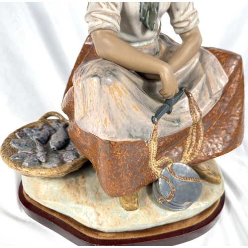 545 - A large Lladro group, seated fish seller, ht. 44cm (small chip to balance scales)