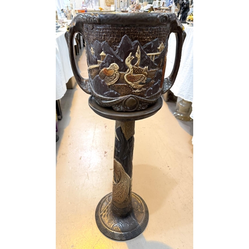 547 - A Bretby style jardiniere decorated with oriental figures, with matching stand (cracked)