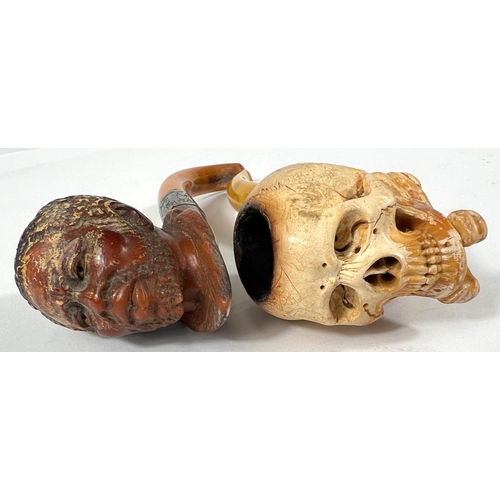 56 - 2 cased amber and Meerschaum pipes depicting skull and crossbones and black man's head.