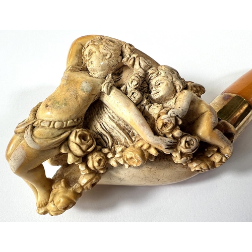 57 - A cased amber and Meerschaum pipe with extensive relief decoration of a reclining woman in flowers w... 