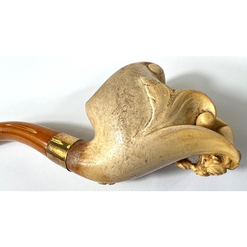 57 - A cased amber and Meerschaum pipe with extensive relief decoration of a reclining woman in flowers w... 