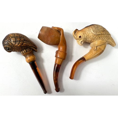 62 - 3 small amber and Meerschaum pipes, including hand holding egg (cracked); perching parrot (cased wit... 