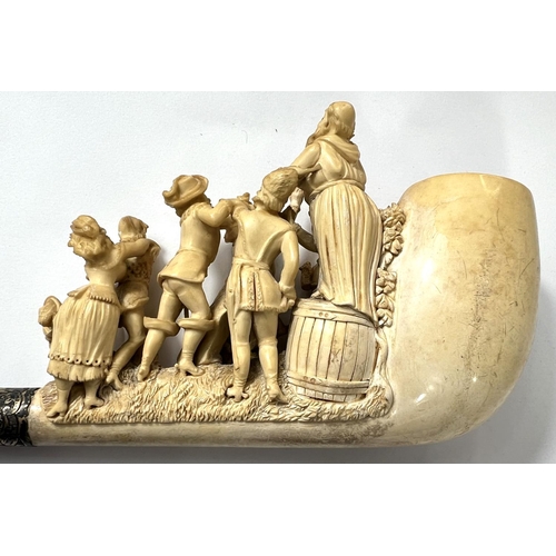 63 - A large amber and Meerschaum pipe, the bowl and stem depicting merry dancing figures and a preacher.... 