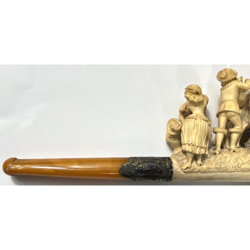 63 - A large amber and Meerschaum pipe, the bowl and stem depicting merry dancing figures and a preacher.... 