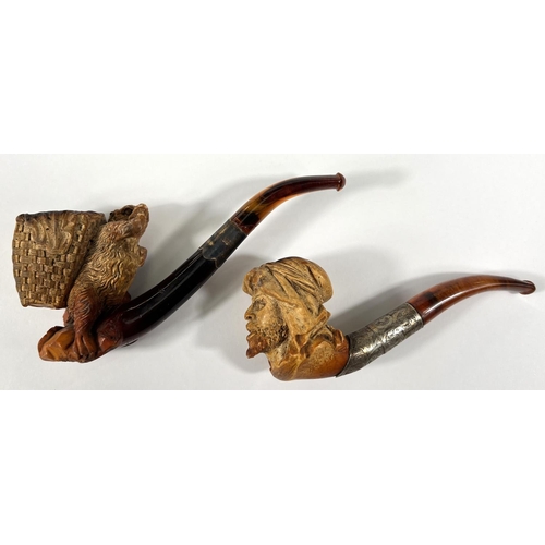 71 - 2 cases amber and Meerschaum pipes, one in the form of a bear with a basket on its back, length 16cm... 