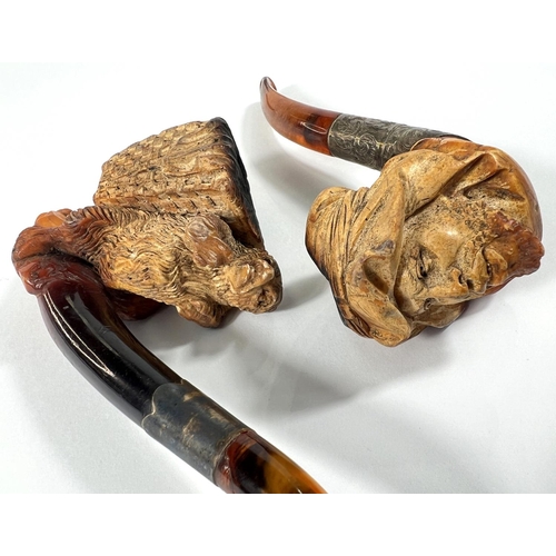 71 - 2 cases amber and Meerschaum pipes, one in the form of a bear with a basket on its back, length 16cm... 