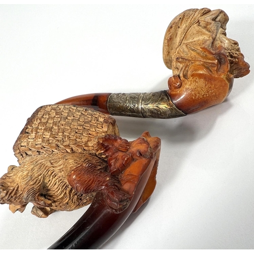 71 - 2 cases amber and Meerschaum pipes, one in the form of a bear with a basket on its back, length 16cm... 