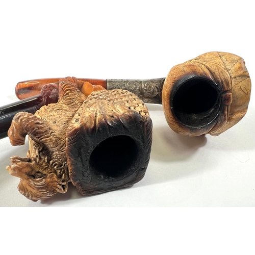 71 - 2 cases amber and Meerschaum pipes, one in the form of a bear with a basket on its back, length 16cm... 