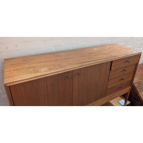 1002 - A mid 20th century dining suite, comprising sideboard, double cupboard and 4 drawers, extending teak... 