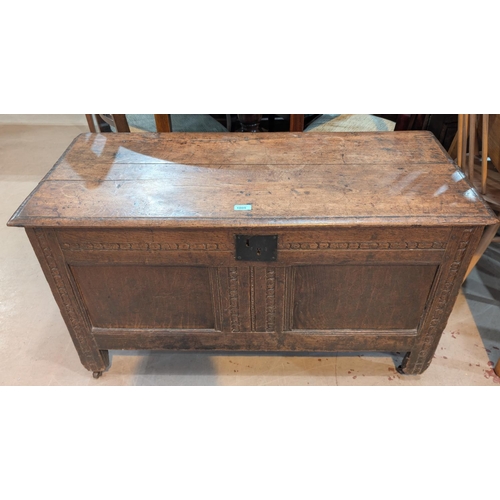 1005 - An 18th century oak coffer chest with carved panels to the front.