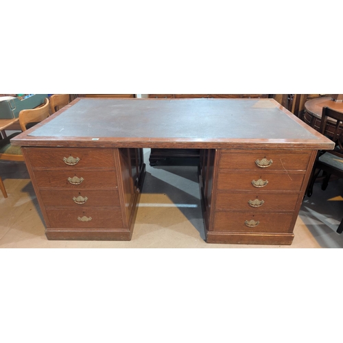 1008 - A large early 20th century oak twin pedestal office desk with inset leather effect top, 8 pedestal d... 