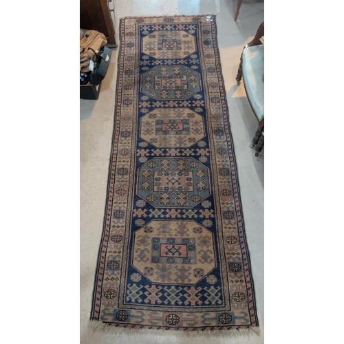 1014 - A blue ground hand knotted Persian runner with 5 octagonal medallions to the field, length 250 x wid... 