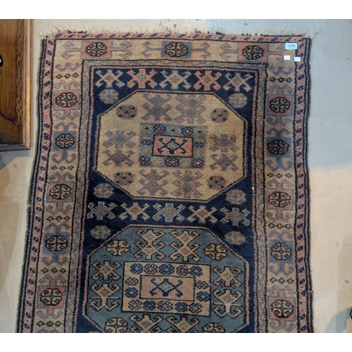 1014 - A blue ground hand knotted Persian runner with 5 octagonal medallions to the field, length 250 x wid... 