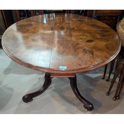 1016 - A Victorian walnut drop leaf dining table circular form with x-shaped fold out base