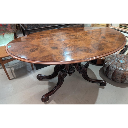 1016 - A Victorian walnut drop leaf dining table circular form with x-shaped fold out base