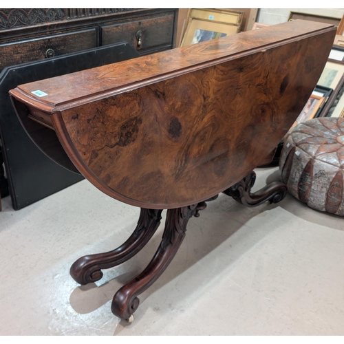 1016 - A Victorian walnut drop leaf dining table circular form with x-shaped fold out base