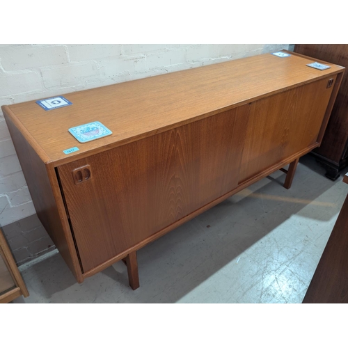 1017 - A mid 20th century Danish teak sideboard with sliding doors, 160cm length, height 77cm