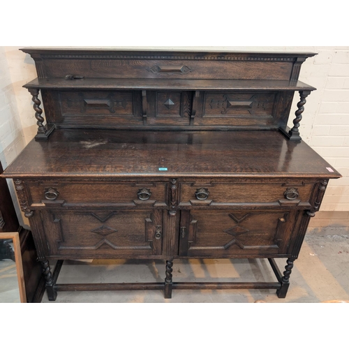 1018 - A 1930's large heavy oak carved sideboard with raised back, barley twist supports drawers and cupboa... 