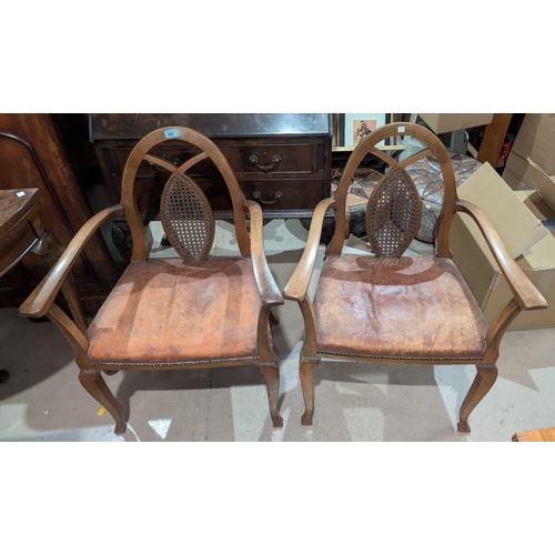 980 - A pair of 1950's arch back arm chairs with studded leather seats