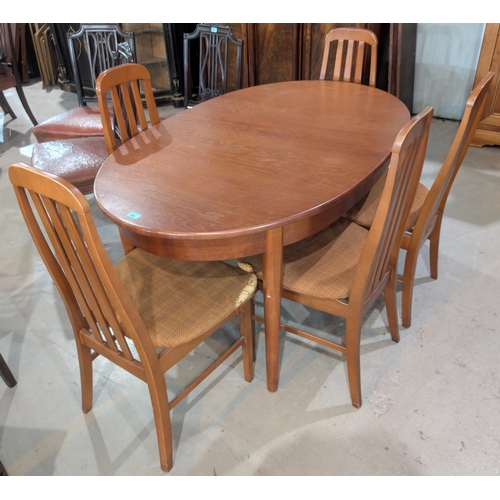 986 - A mid 20th Century teak dining table in the G-Plan manner, oval with extending interior leaf and six... 