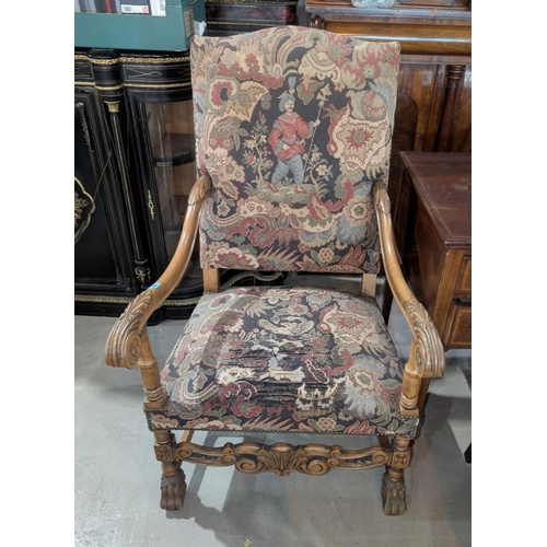 988 - An oak framed high back tapestry chair with carved arms and heavy paw feet; an alabaster lamp.