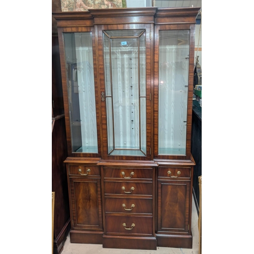 989 - A reproduction full height mahogany break front library bookcase with glazed cupboard above and draw... 