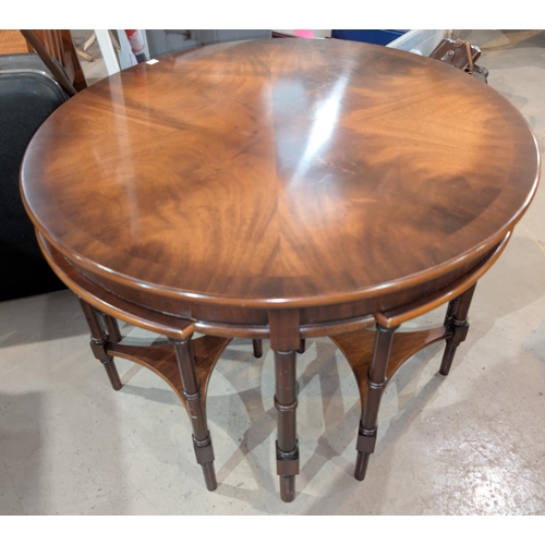 991 - A circular figured mahogany Reprodux  coffee table with 4 quartered occasional tables below