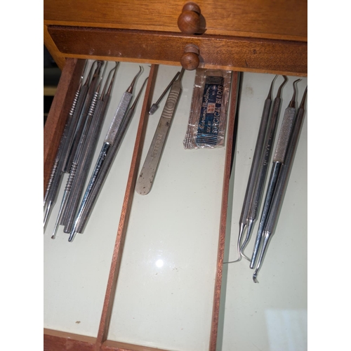 320 - A Mid 20th century dentist cabinet with six drawers with vintage dental equipment in each drawer