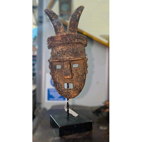 375C - A late 19th/early 20th century carved African wooden mask on stand