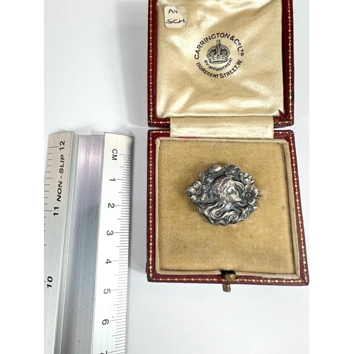 708 - A silver Art Nouveau brooch of female head in red leather box