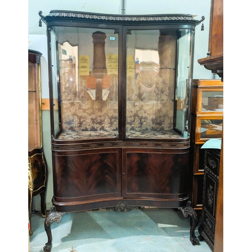 999 - An early 20th century mahogany reverse bow front period style display cabinet with carved cornice an... 