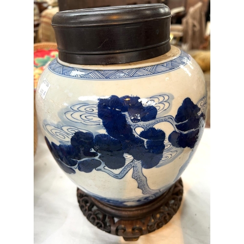 433A - A Chinese blue and white ginger jar on associated stand with wooden decorated with trees and animals... 