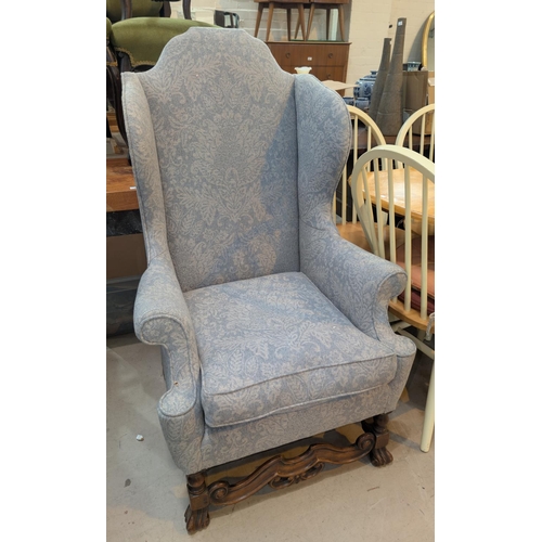 867 - A high back arm chair upholstered in grey