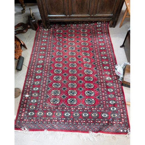 848 - A red ground 20th Century hand knotted Middle Eastern carpet with three rows of central medallions.