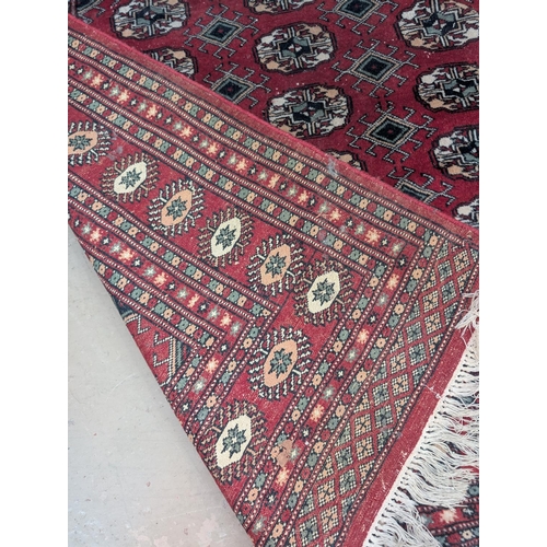 848 - A red ground 20th Century hand knotted Middle Eastern carpet with three rows of central medallions.