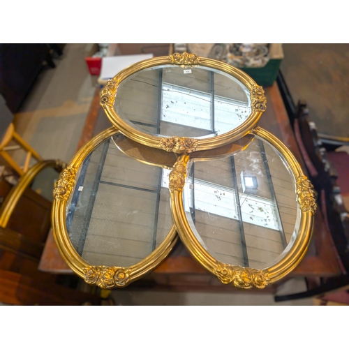 859 - Four oval wall mirrors.