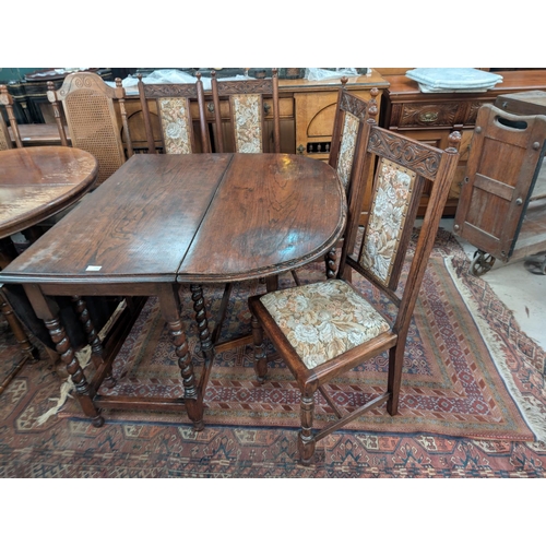 841 - An oak barley twist drop leaf dining table and a set of six carved oak dining chairs.