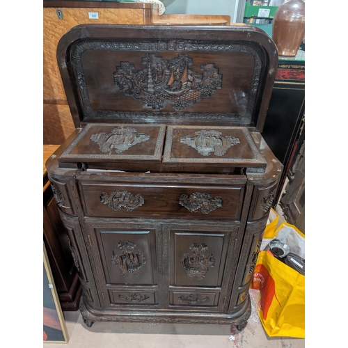 843 - A 1920's Chinese carved cocktail cabinet with carved parrots, rounded form, pop up secret compartmen... 